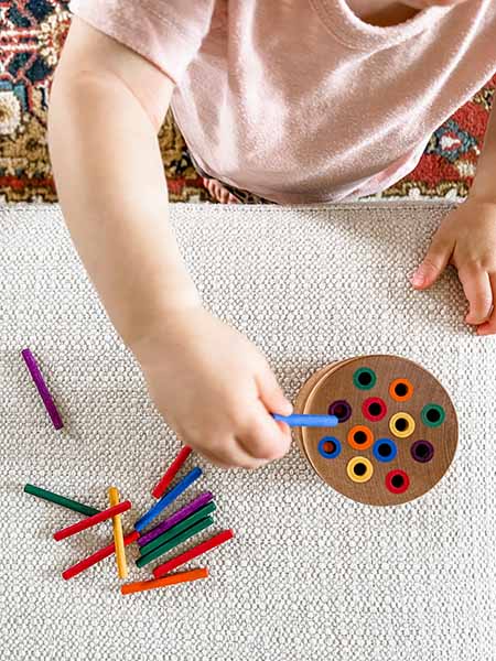 Enfant en pleine activité Montessori, moment typique en garde à domicile ou chez une assistante maternelle