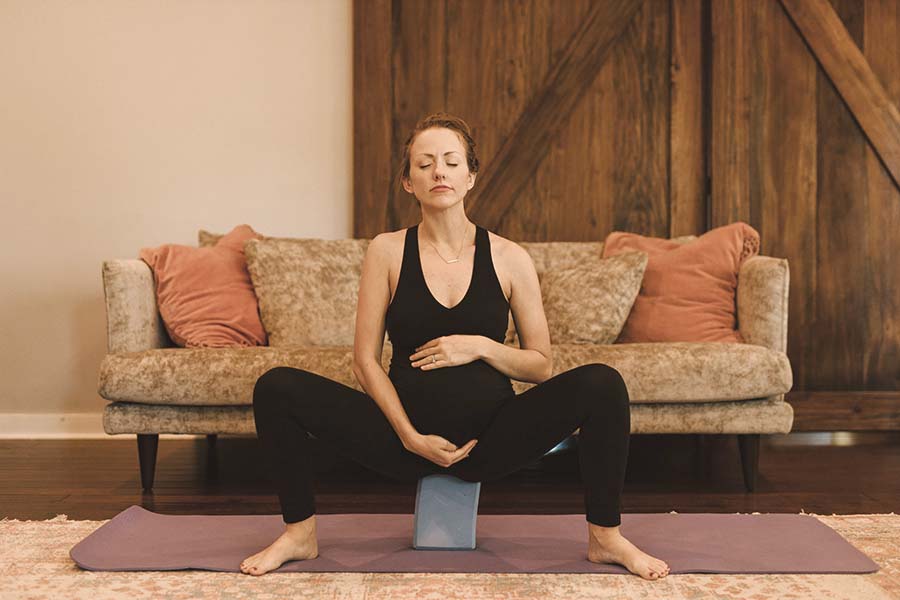 Femme enceinte pratiquant une posture de yoga prénatal pour se préparer à un accouchement sans péridurale