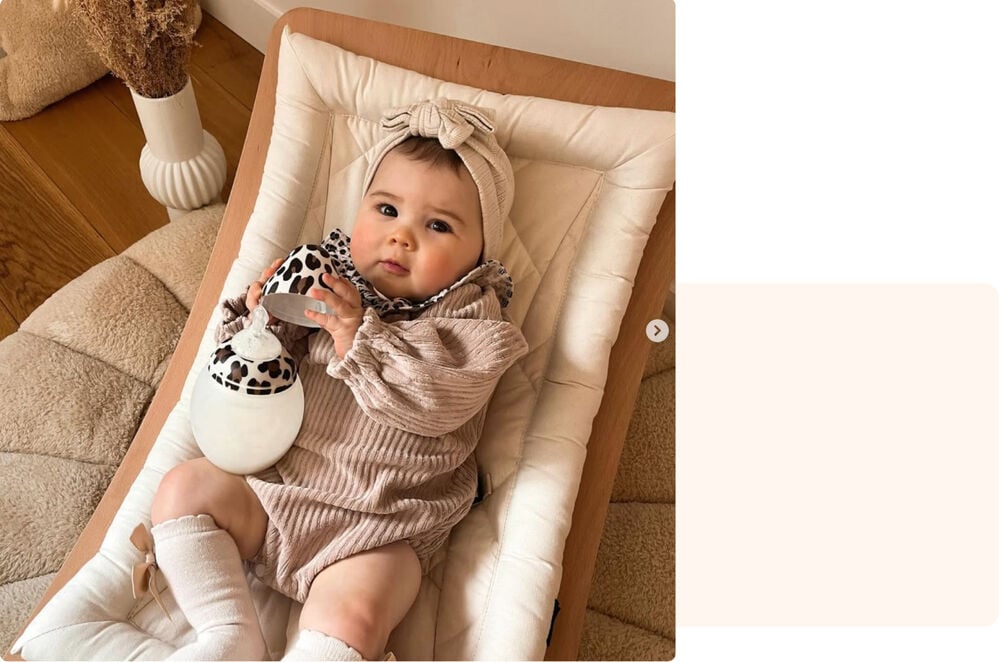 Bébé de 2 mois dans son transat avec biberon, portrait jeune maman