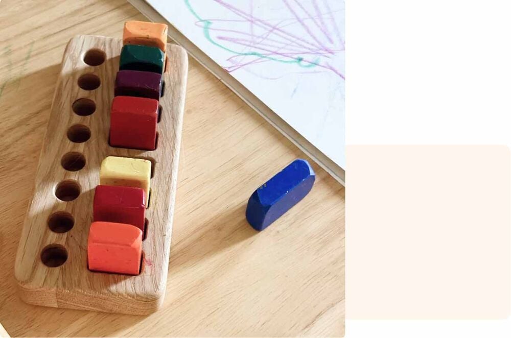 Gros crayons de cire colorés alignés sur un support en bois, activité bébé 11 mois pour développer créativité