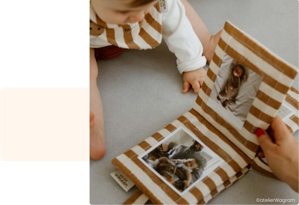 Bébé feuilletant un petit album photo en tissu avec un adulte, activité bébé 10 mois famille