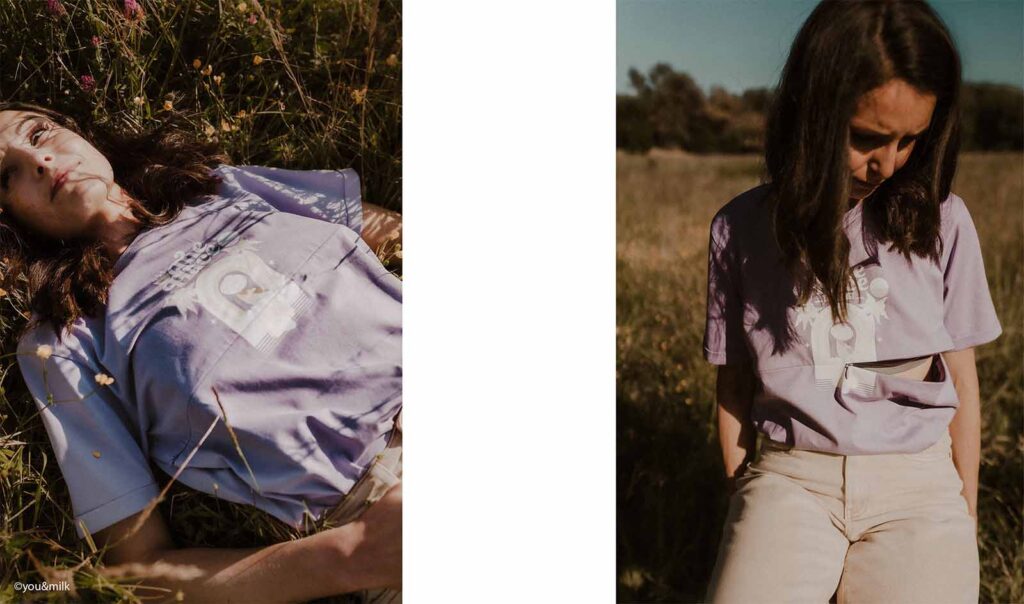 mère allongée dans un champ fleuri portant un t-shirt lilas, célébrant la maternité en pleine nature
