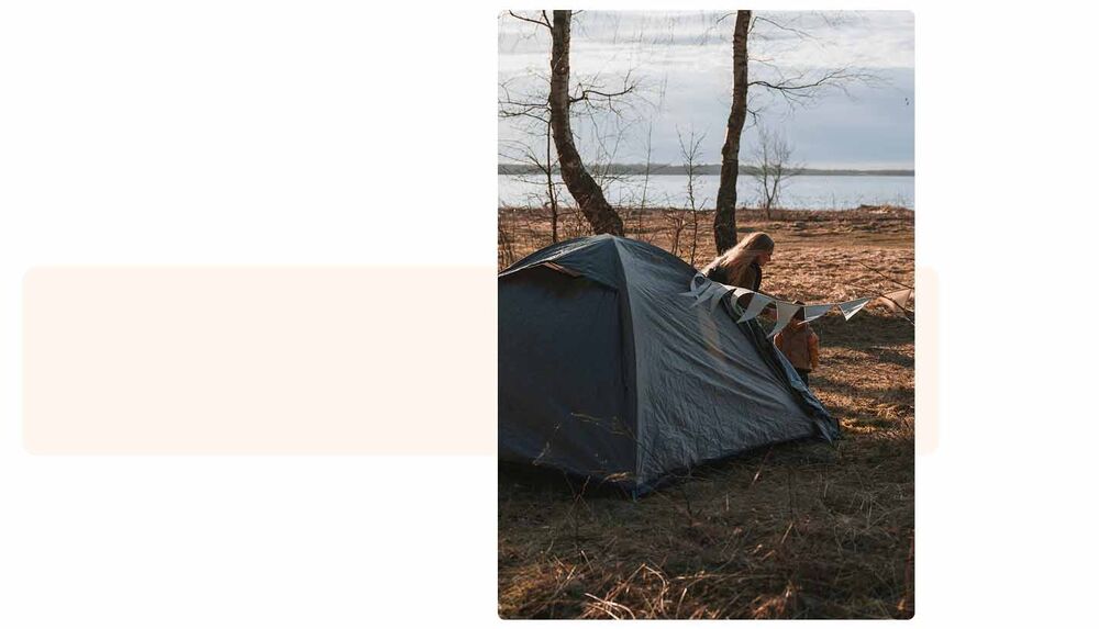 Femme montant une tente au bord d'un lac en nature, faire dormir bébé au camping, choisir la bonne tente spacieuse et bien aménagée