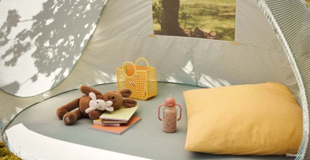 Tente anti-UV bébé installée en extérieur avec jouets et gourde, pourquoi protéger bébé de la chaleur dès le plus jeune âge