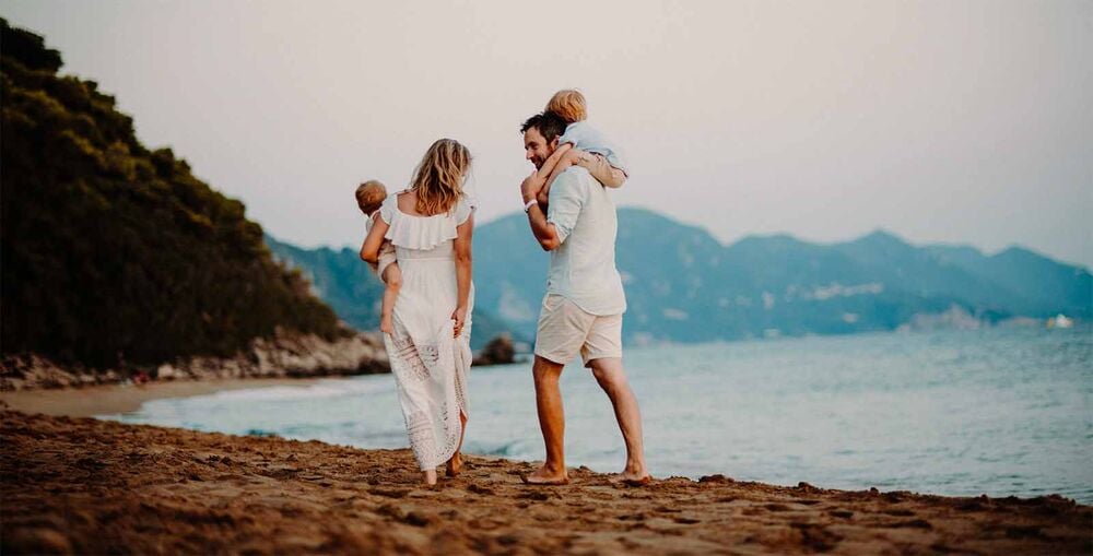 Parents et deux enfants se promenant sur la plage au coucher du soleil, projet familial en famille recomposée, avancer ensemble vers un nouveau chapitre